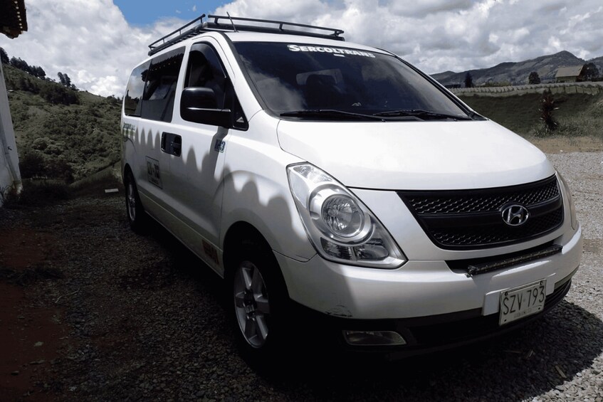 A white van parked on a gravel road with a license plate SZV 793. 3