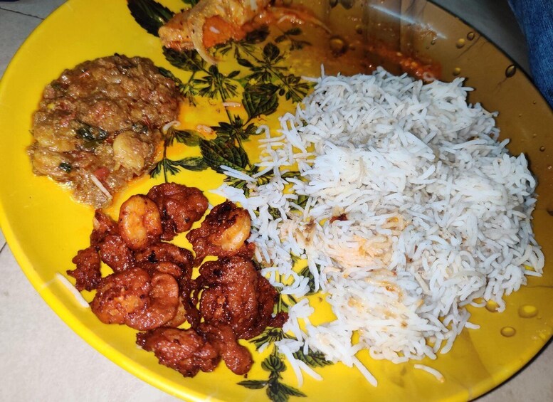 A plate with white rice, a meat dish, and a side of fried items. 5