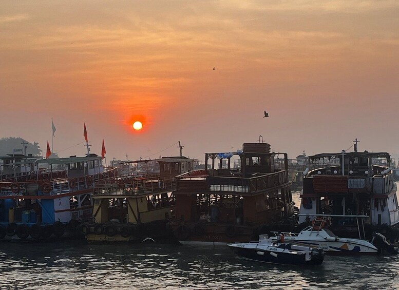 A sunset over a harbor with boats and buildings. 5