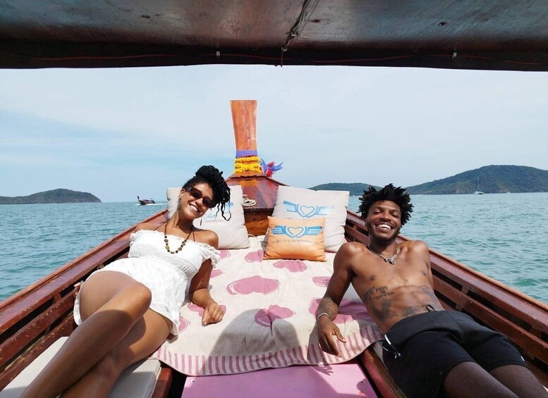 Two people on a boat with a view of the sea and distant islands. 2