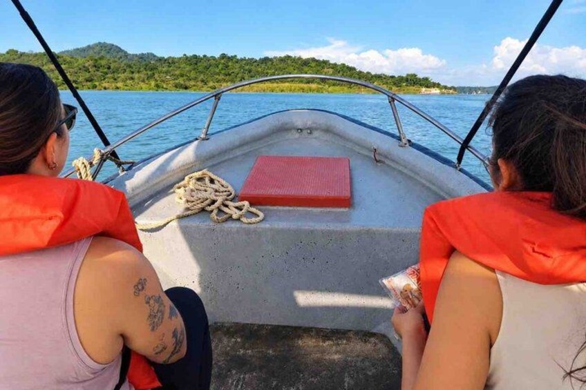 Dos personas en un bote con chalecos salvavidas, una cuerda y un tapete rojo. 2