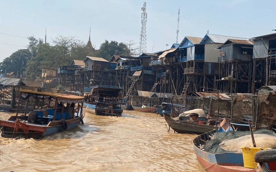 A river with boats and wooden houses on stilts. 1