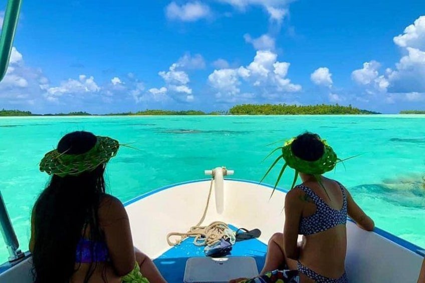 Two people on a boat in turquoise waters, surrounded by clear skies and distant land. 1