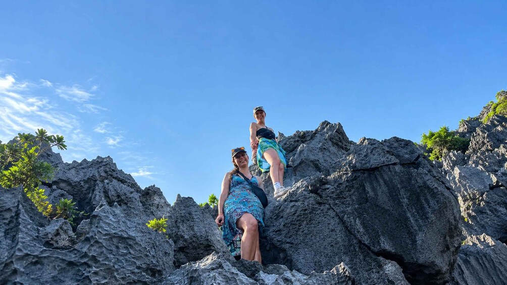 Two people hiking on rocky terrain with sparse vegetation. 2