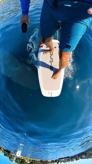 A person riding a wakeboard on a body of water. 2