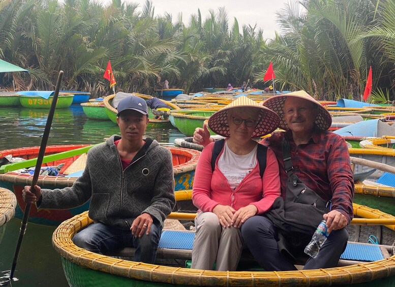 Three people sitting on a boat surrounded by other boats, with palm trees in the background. 3
