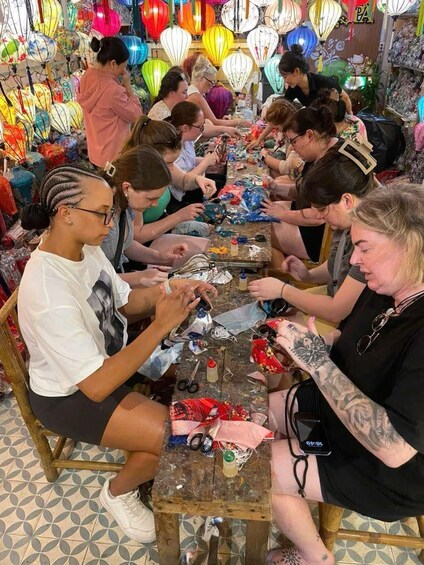 A group of people engaged in a craft activity, surrounded by colorful lanterns. 4