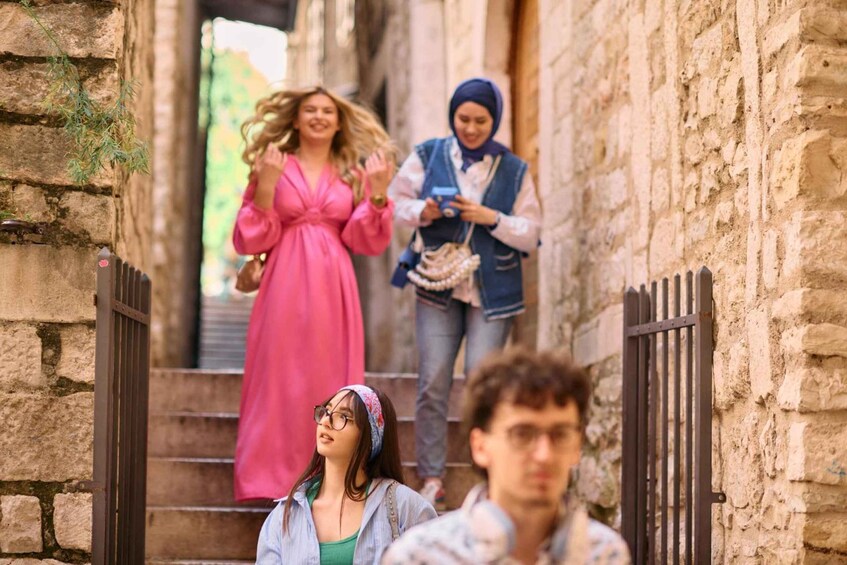A stone staircase in a narrow alleyway with people walking up and down. 4