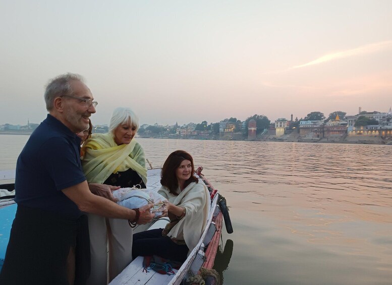 A group of people on a boat near a river with buildings in the background. 5