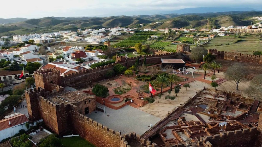 A historic fort with surrounding gardens and a town in the background. 1