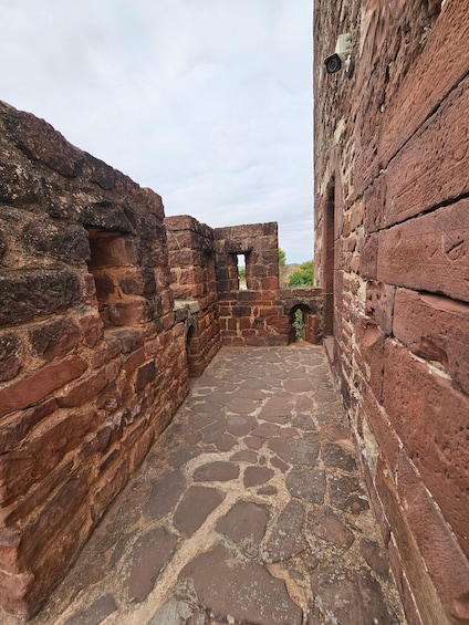 An ancient stone courtyard with brick walls and a cobblestone floor. 3