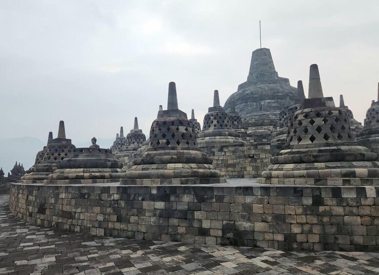 A temple complex with multiple stone stupas and a central tall structure. 5