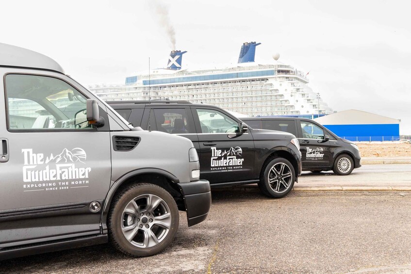 Two vehicles with 'The GuideFather' branding parked in front of a cruise ship. 2