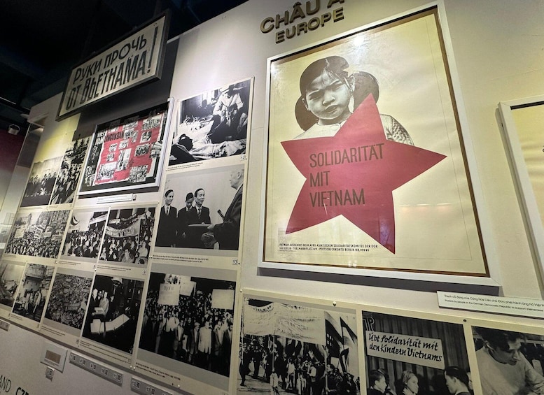 A wall displaying various historical posters and photographs, including one prominently featuring 'Solidarity with Vietnam'. 5