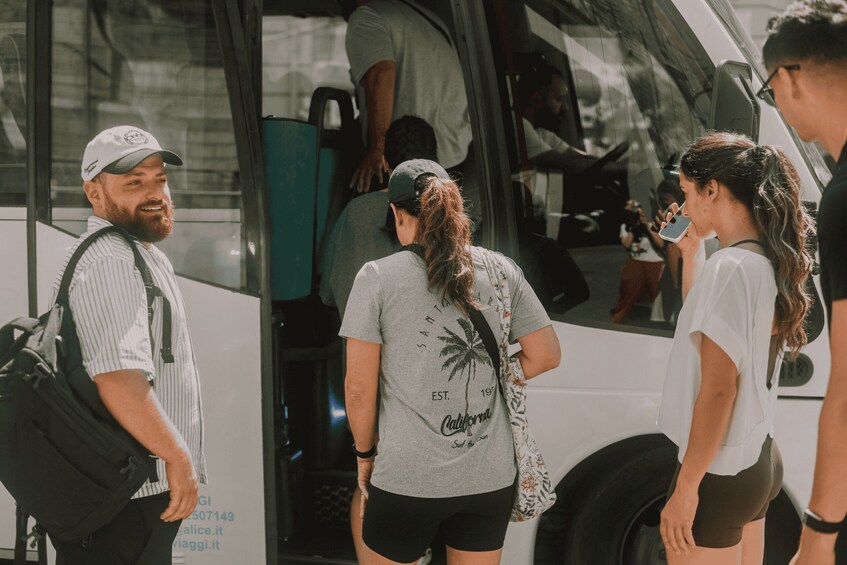 People boarding a bus with a tropical palm tree design on a t-shirt. 5