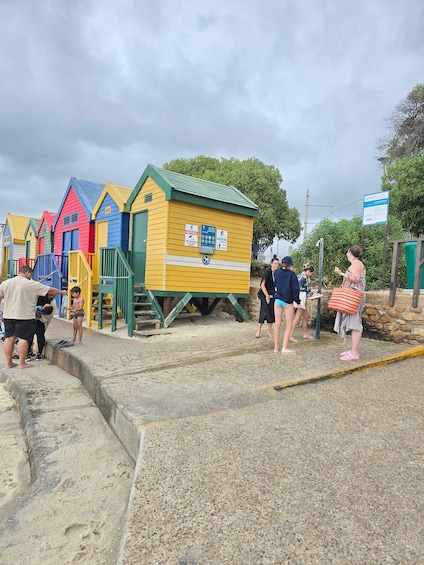 Des cabanes de plage aux couleurs vives, une plage de sable et des gens qui se promènent. 4