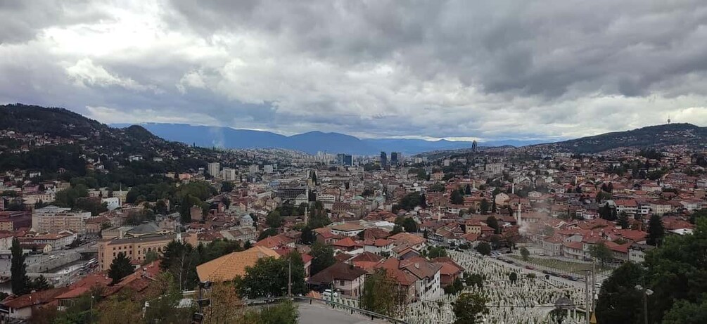A cityscape with a prominent church, a large mosque, and a hill in the background. 3