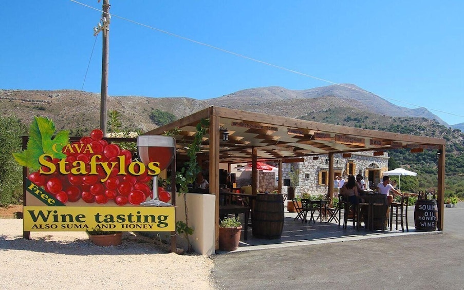 A wine tasting area with a sign for Cava Stafylos, also offering suma and honey. 3