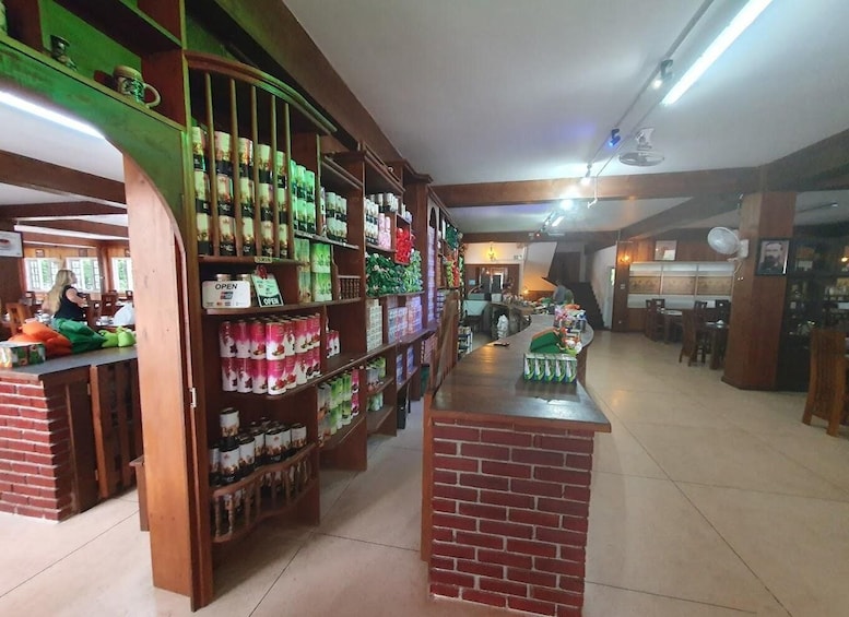 A store with shelves stocked with canned goods and a counter with beverages. 4