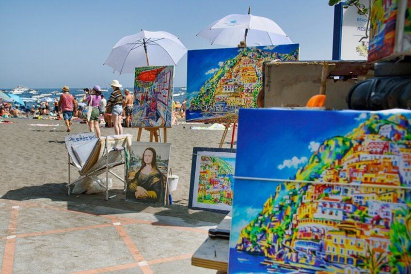 Een strand met kunstkraampjes en parasols. 3