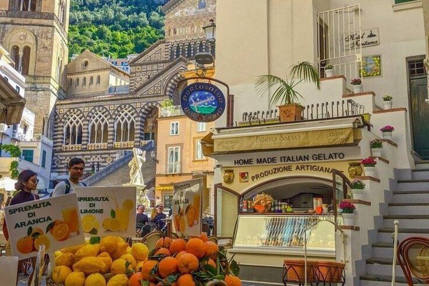 Een straatmarkt met een ijskar en een bord waarop staat 'Home Made Italian Gelato'. 2