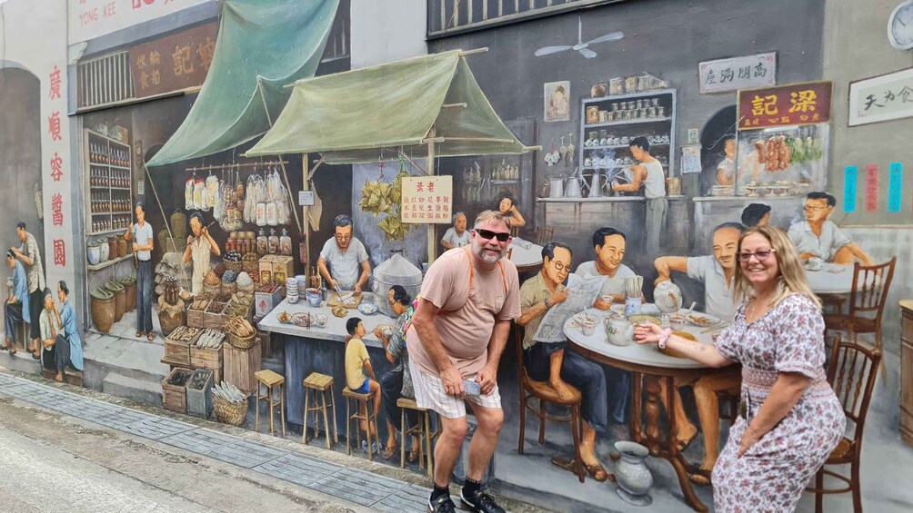 A mural of a bustling street scene with people sitting at tables, vendors selling goods, and a variety of items displayed on shelves. 4