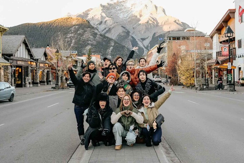 A group of people posing in a town square with a mountain in the background. 1