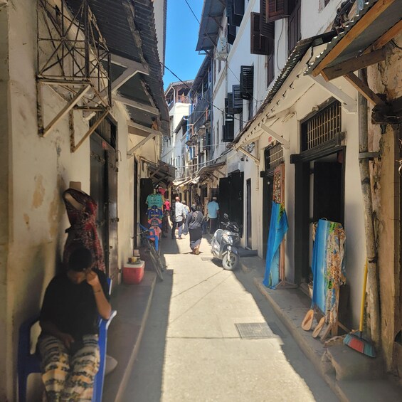 A narrow street lined with buildings, some with visible wear and tear. 5