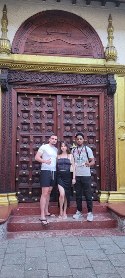 A large ornate wooden door with intricate carvings and a golden frame. 1