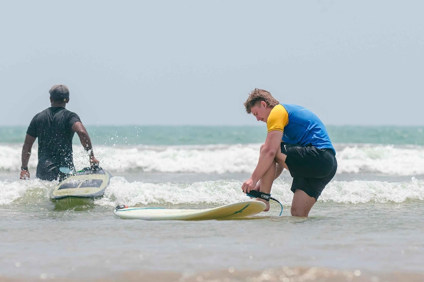 Two people on surfboards at the beach with waves. 2