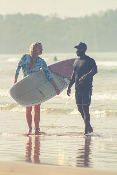 A person holding a surfboard on a beach with waves. 3