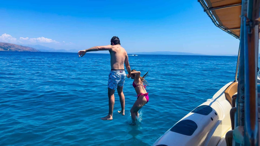 A man and a woman in swimwear on a boat in the ocean. 1