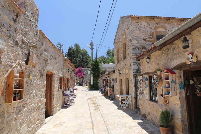 A narrow stone street with shops and outdoor seating. 2