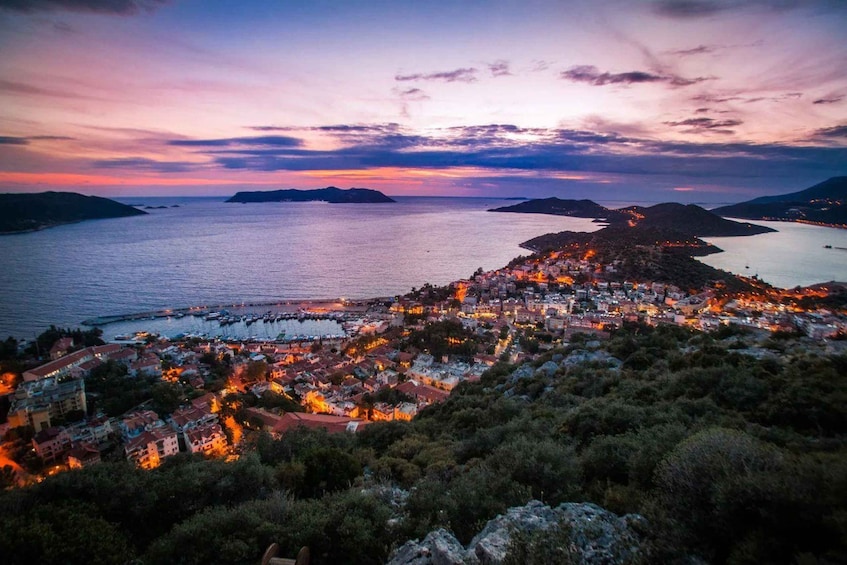 A coastal town at dusk with a view of the sea and distant islands. 5
