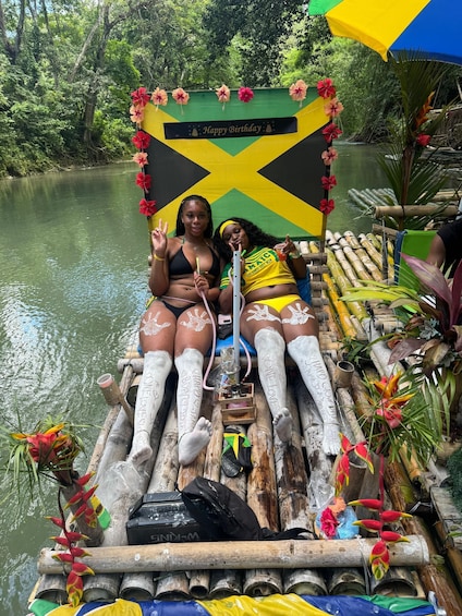 Two people on a boat decorated with flowers and a 'Happy Birthday' banner. 1