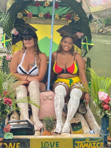 Two women in a boat decorated with flowers and flags, with a sign reading 'Birthday Princess'. 4