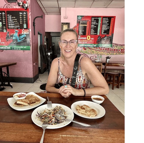 A person sitting at a table with food in a restaurant. 2