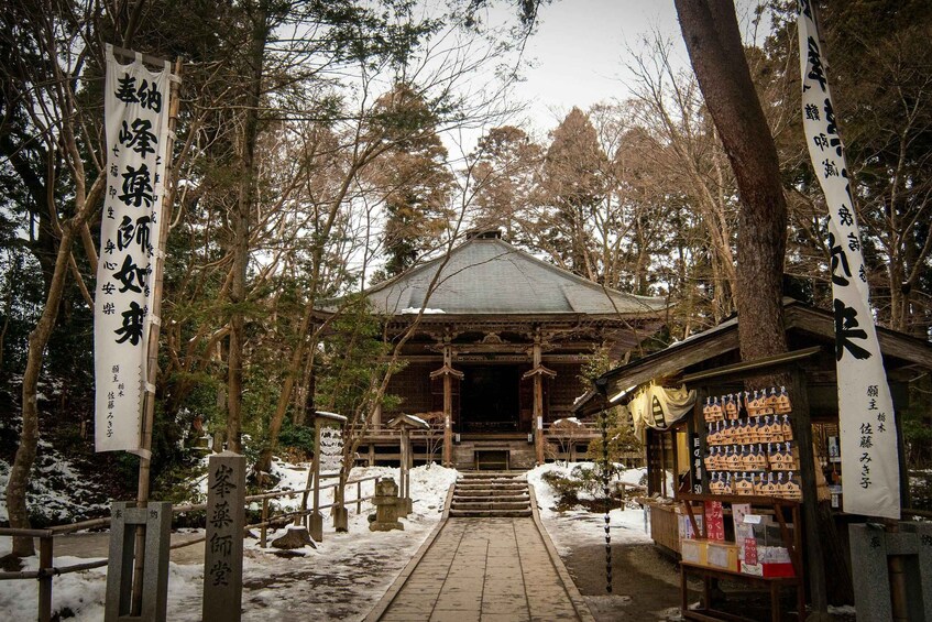 A traditional Japanese temple with snow-covered ground and wooden structures. 5