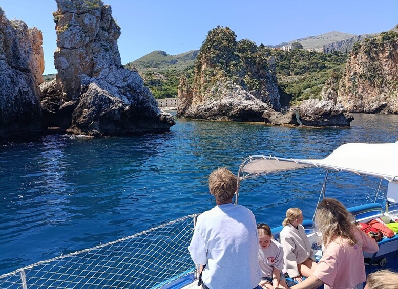 A boat with people on a rocky coastline. 2