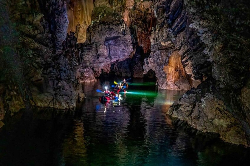 A cave with water and kayaks inside. 2