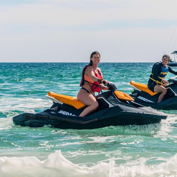 Deux personnes font du jet-ski sur une eau turquoise. 2
