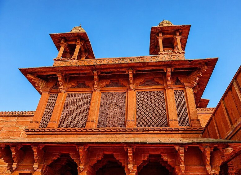 A historic building with intricate carvings and a clear blue sky. 5