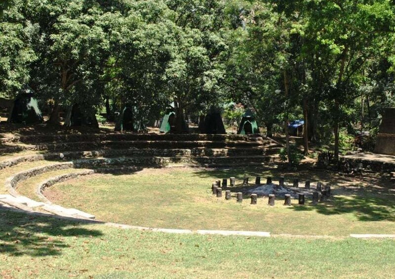 A park with stone structures and green tents. 3