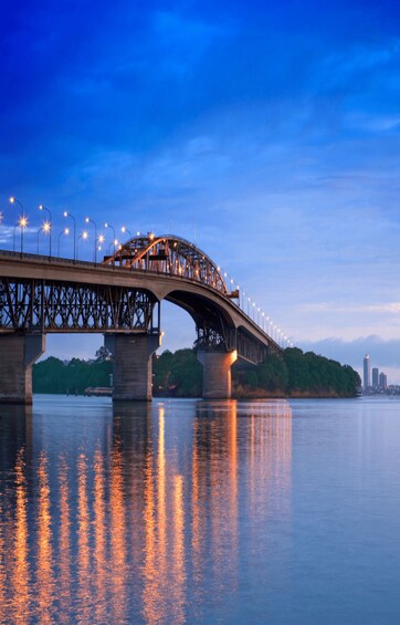A bridge with streetlights reflecting on the water. 2