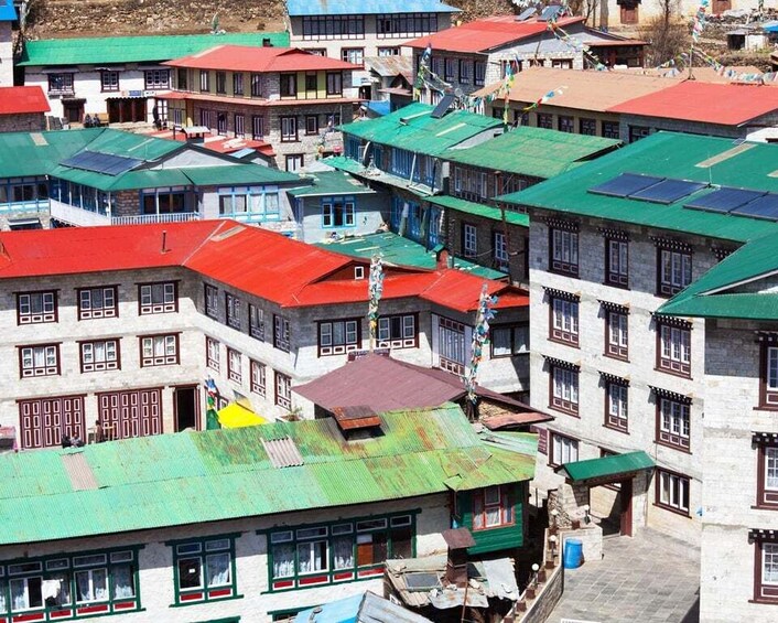A densely packed village with colorful buildings and green roofs. 5