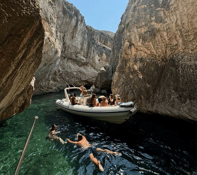 A boat with people on a narrow waterway between rocky cliffs. 2