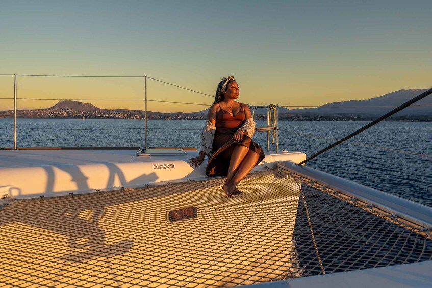 Una persona sentada en la cubierta de un barco, con un paisaje montañoso al fondo. 2