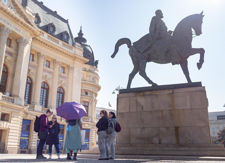 A statue of a man on horseback in front of a historic building with columns. 5