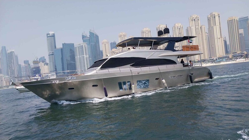 A luxury yacht cruising on water with a city skyline in the background. 1