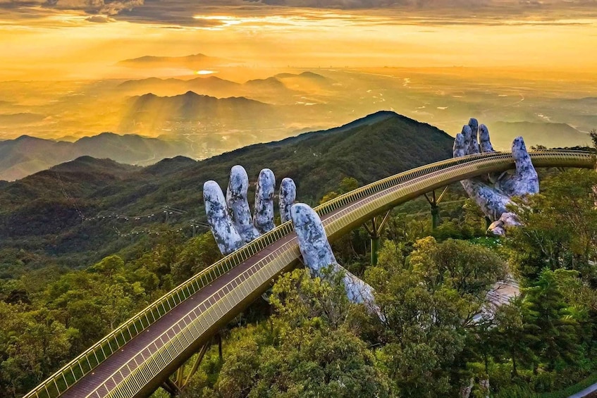 A bridge with a unique hand-shaped design, surrounded by lush greenery and mountains. 1